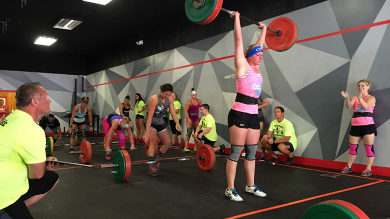 Female competitors performing WOD 1 Cluster ladder during Downtown Throwdown II.