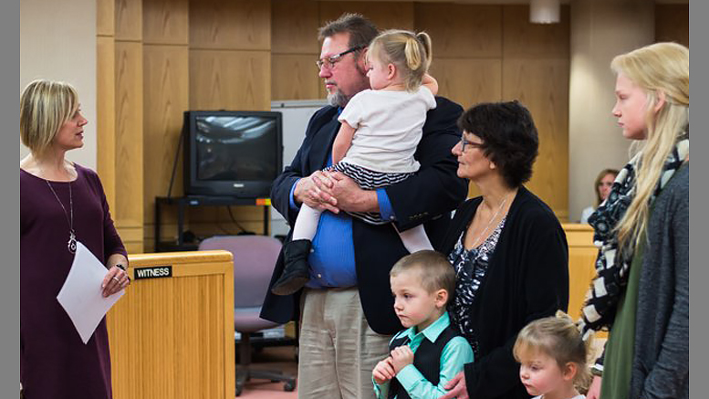 A family adoption is finalized on November 17th in the Delaware County Justice Center. Photo by: Jeneca Zody