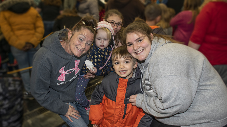 A family poses for a picture during the 25th annual Tiny Adams Memorial Christmas event held at fire station #1 in downtown Muncie. Photo by: Mike Rhodes