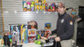 Firefighter Daniel Powell puts together a bag of new toys for a local family inside the Toys For Tots office in Southway Plaza. Photo by: Mike Rhodes