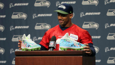 During one of his regular weekly press conferences in November, Wilson unveiled his cleats, telling reporters Sydney “did an amazing job with them.” (Photo courtesy of Seattle Seahawks)