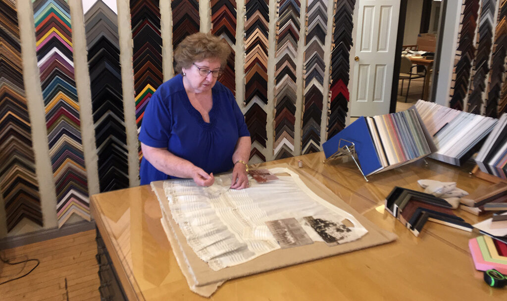Rosie Sampley works on an early 20th century apron worn by a Pennsylvania teacher and now being framed and preserved by her family. Rosie has over thirty years of framing experience. Photo provided