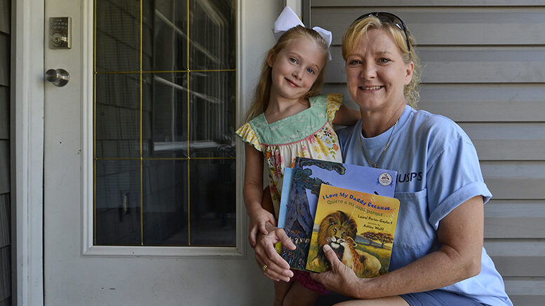 Four-year-old Isabelle Rabenstein receives books from Dolly Parton’s Imagination Library, delivered by letter carrier Debbie Edwards Thompson. Isabelle is the daughter of Jordan and Zach Rabenstein. Photo provided