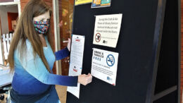 MPL facilities staff post signs for the new Smoke & Tobacco Free Policy. Photo by Susan Fisher