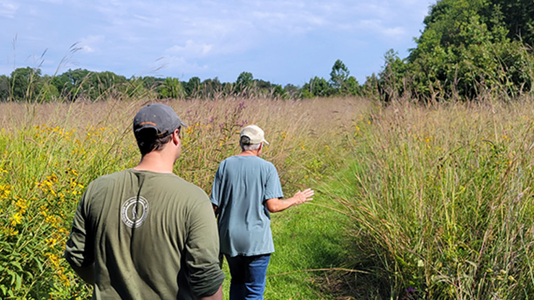 Red-tail's Stewardship Coordinator Jake Gamble (Left) tours Steussy-Williams Conservation Easement, a former alfalfa field that has been restored to prairie and forest, with landowner Helen Steussy (Right).