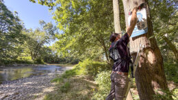 A volunteer installs one of 69 new White River mile marker signs—part of a Ball Brothers Foundation-funded safety project. The markers, integrated with Delaware County’s 911 system, will help emergency responders quickly locate and assist individuals along the river. Photo provided.
