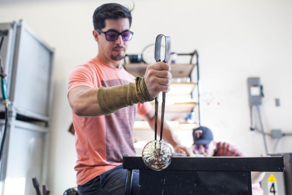 Dylan Martinez, a graduate student studying glassmaking at Ball State, works on an ornament that will be for sale at Ball State’s glass ornament sale Dec. 3 and 5. Proceeds will help fund a May 2016 trip the students are taking to study glassblowing techniques in Poland. Photo provided.