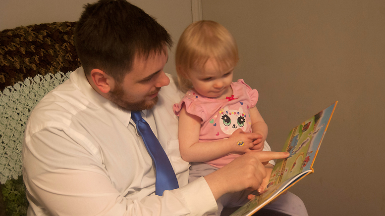 Nate Rose and his daughter Noelle reading the first Imagination Library book, "The Little Engine That Could." Photo provided.