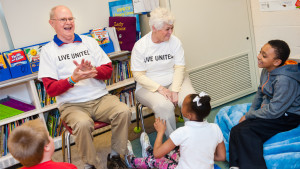 Reading Club volunteers Ben and Karen Howells engage students during Reading Club at Longfellow Elementary School. On average, Reading Club volunteers give 60 hours of their time helping students during a school year. Photo provided.