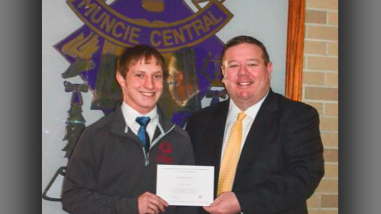 Senior Cory Cooper receives a Certificate of Merit from Principal Chris Walker for qualifying as a Merit Scholarship® Finalist. Photo provided.