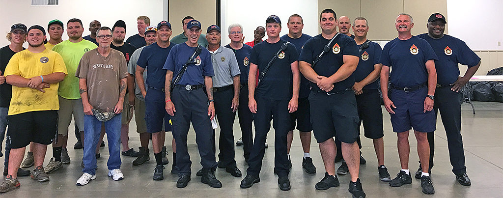 Volunteers from the City of Muncie Parks Department, Muncie Sanitary District and Muncie Fire Department are pictured after moving thousands of backpacks to the fairgrounds. Photo by: Kay Walker