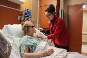 A nurse on the 9N Adult Surgical Unit checks a patient’s vital signs during morning rounding.