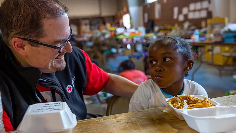An American Red Cross volunteer calms a small child. Photo provided.