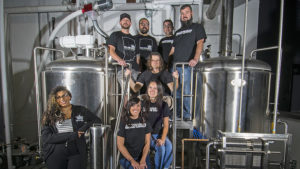 Pictured standing on the 15 barrel brew house—Men: (Top Row L-R)—Bill Kerr, Kyle Johnson, Sean Fickle, Jarrod Case, Jason Phillips. Women: (L-R) Felix Buck, Talia Schroeder, Jennifer Chrich. Photo by: Mike Rhodes