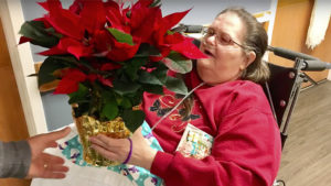 A resident is pictured with her poinsettia during "Project Poinsettia." Photo by: Liz Valpatic