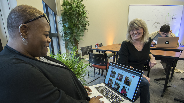 Watasha Griffin (L) is pictured reviewing the new Martin Luther Dream Team website, while Susan Fisher (R) looks on during the 2018 Website Thru The Night event. Photo by: Mike Rhodes.