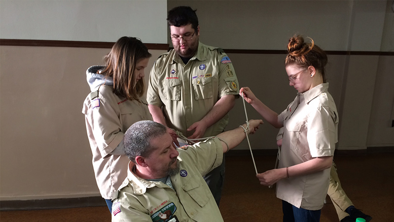 Moira Teal (left) and Anneka Tschuor (far right) tie knots on Mitch Teal’s arm as Charlie Murphy looks on. Photo by: John Carlson