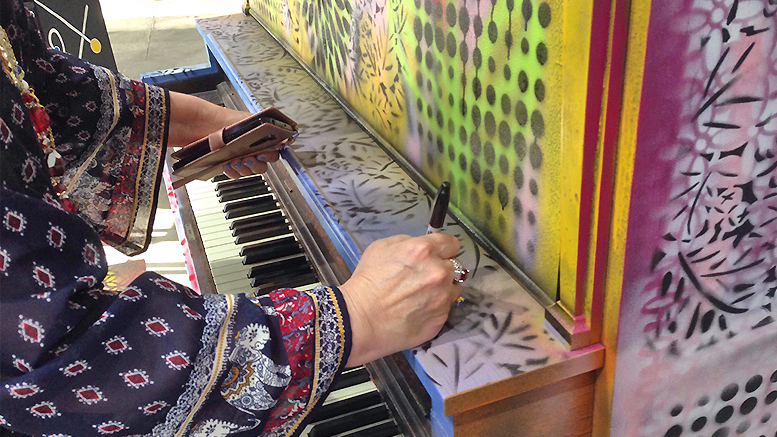 Debra Gindhart signs her piano at Madjax's Second Thursday event on July 11, 2019. Gindhart titled her work Sing, Dance and Grow Merriment. Photo provided