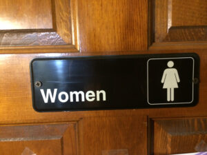 What’s behind a sign like this? The ladies aren’t saying. Photo by: Nancy Carlson