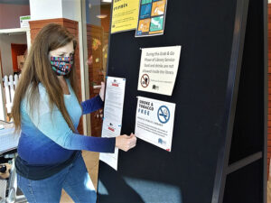 MPL facilities staff post signs for the new Smoke & Tobacco Free Policy. Photo by Susan Fisher