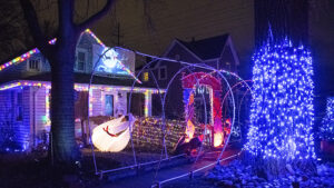 This home display in the 700 block of West 11th Street has a lot going on within it including Santa and his sleigh projected on a screen from the 2nd story. Photo by Mike Rhodes