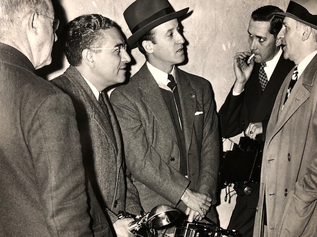 Joe Costa and other New York photographers talk with famous columnist Walter Winchell, circa 1938. Printed by Dick Ware from a negative supplied by Joe Costa. Costa is second from the left. Photo provided by Sheryl Swingley