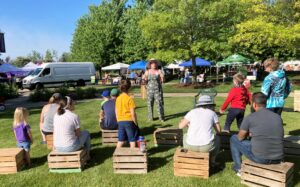 Katie Lehman, Ready Readers Supervisor at MPL, conducts an outside story time at the recent Garden Fair at Minnetrista Museum & Gardens. Photo by Sidney Barkdull, Ready Readers Specialist at MPL.