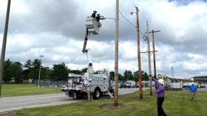 Muncie Mayor Dan Ridenour is pictured in the bucket truck during a mock demonstration of the streetlight conversion. WLBC's Steve Lindell is seen below, videotaping the mayor. Photo provided by Indiana & Michigan Power