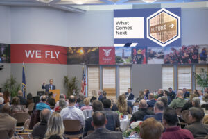 Muncie Mayor Dan Ridenour is pictured giving his 3rd annual State of the City report at the Ball State Alumni Center. His slide presentation appeared on numerous television monitors circling the meeting room. Photo by Mike Rhodes