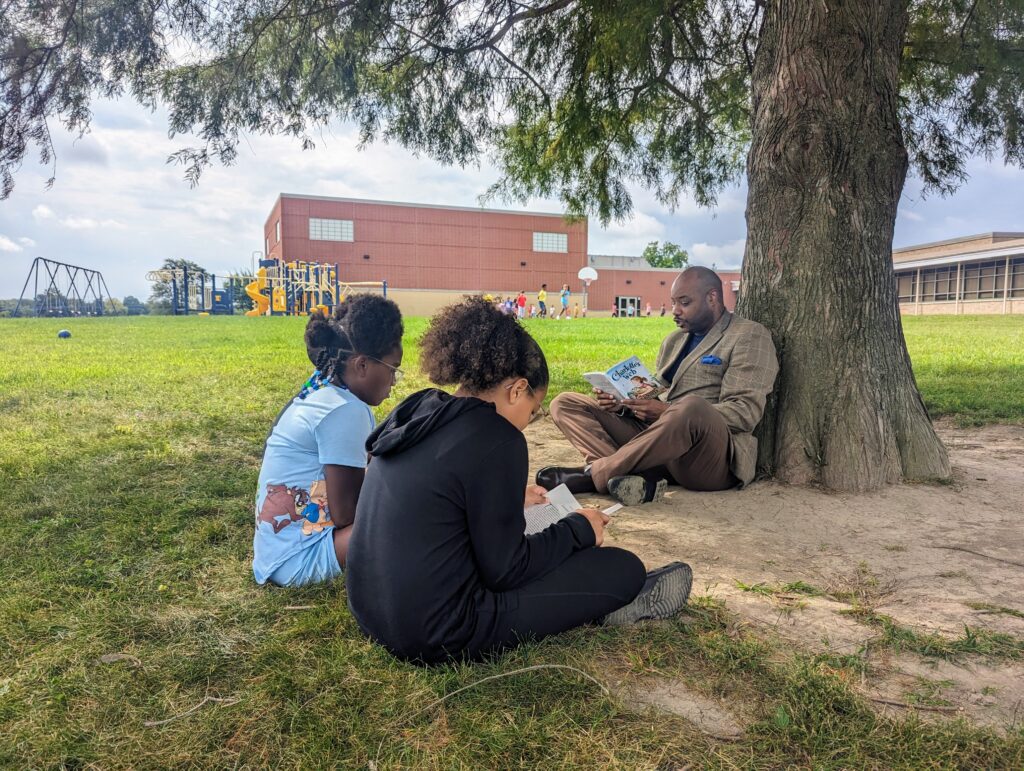 Longfellow Elementary School Principal Gerry Moore reads Charlotte’s Web to Isabella Foster and A’Nyiah Shannon.