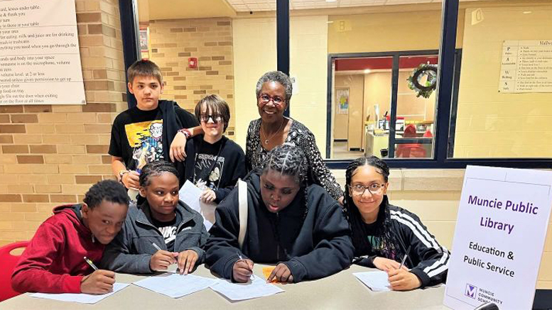 MPL Library Director, standing at right, poses with Southside Middle School students at a 2023 school event. Photo provided by Muncie Public Library.