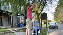 President Brad King and Vice-President Nicole Rudnicki are pictured hanging new signs in the Old West End neighborhood. Photo provided