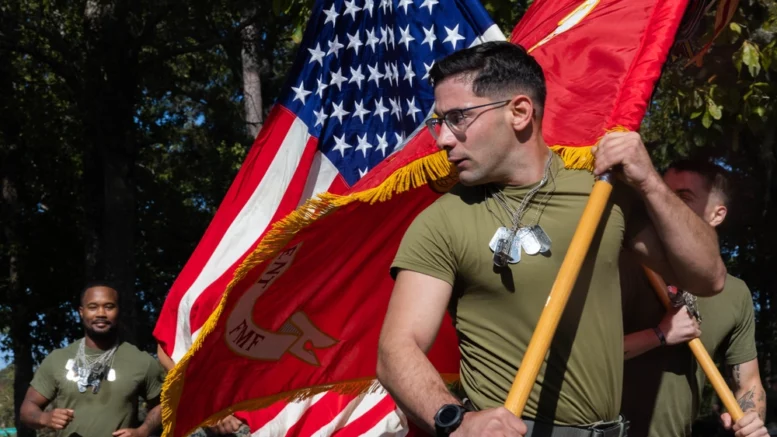 U.S. Marine Corps 2nd Lt. Matthew George, left, an infantry officer with 1st Battalion, 8th Marine Regiment, 2d Marine Division, glances back while holding a 6th Marine Regiment flag during a memorial run at Lejeune Memorial Gardens in Jacksonville, North Carolina, Oct. 22, 2024. The run was held to honor the lives lost after the Beirut, Lebanon bombings on Oct. 23, 1983. (U.S. Marine Corps photo by Pfc. Luke Rodriguez)